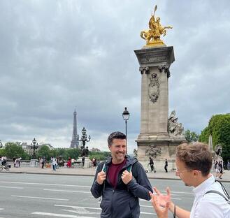 a guide and a guest talking about the eiffel tower on the alexander the 3rd bridge