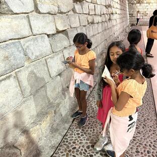 Kids in the dry moat of the Louvre looking for secret signs