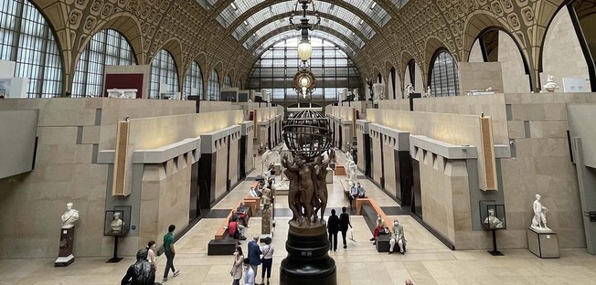 this is a view of the great hall of orsay with globe held by four character in the very from