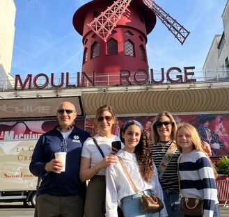 family starting their montmartre tour at the moulin rouge