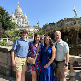 a happy family in montmartre with a carrousel and the Sacré Coeur