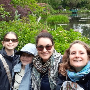 an happy family and a guide taking a selfy in front of the nympheas and the bridge