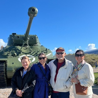 a family of multiple generation touring in the normandy dday beaches posing for a picture in front of sherman from the american army in the second world war