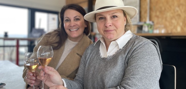 two girls smiling and drinking champagne at legallais