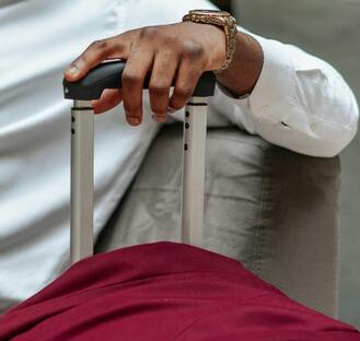 a man holding the handle of his suitcase